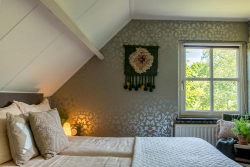 a bedroom with a bed and a window at Gastenverblijf Het Voorhuis in Herpen
