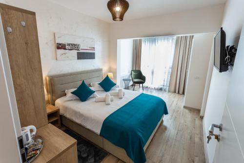 ein Hotelzimmer mit einem großen Bett mit blauer Bettwäsche in der Unterkunft CASA MALVINA in Buşteni