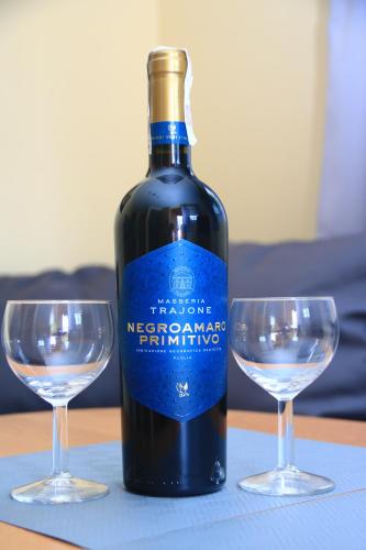 una bottiglia di vino accanto a due bicchieri su un tavolo di Domki Pod Złotym Dębem a Kąty Rybackie