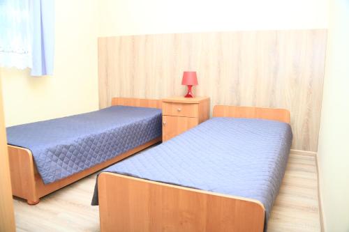 コンティ・リバツキエにあるDomki Pod Złotym Dębemのベッド2台、ナイトスタンド(ランプ付)が備わる客室です。