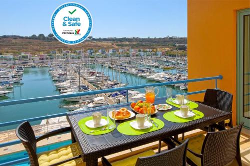 a table with food on a balcony with a marina at Marina Sand Residence in Albufeira