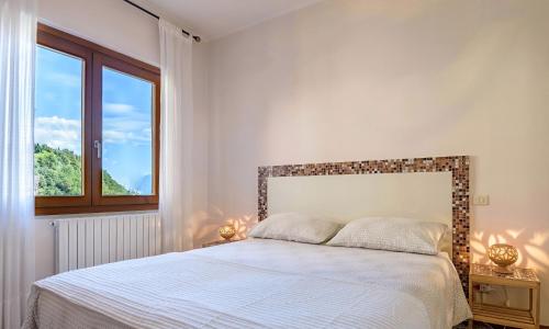 a bedroom with a bed and a window at Casa Artis in Gravedona