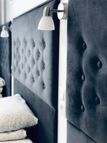 a bedroom with a bed with a headboard and a lamp at SIECHNICE Noclegi in Siechnice