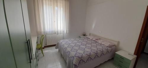 a small bedroom with a bed and a window at Appartamento Raffaello in Cattolica