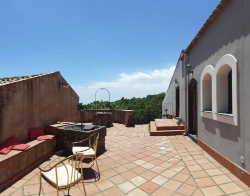eine Terrasse mit 2 Stühlen und einem Waschbecken in einem Gebäude in der Unterkunft Intero alloggio - Casale a Sant'Alfio immerso nel verde in SantʼAlfio