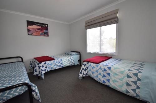 a bedroom with two beds and a window at The Lazaret in Kingscote