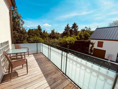 a balcony with a table and a chair on a deck at Ferienwohnungen Weingut Kilburg in Brauneberg