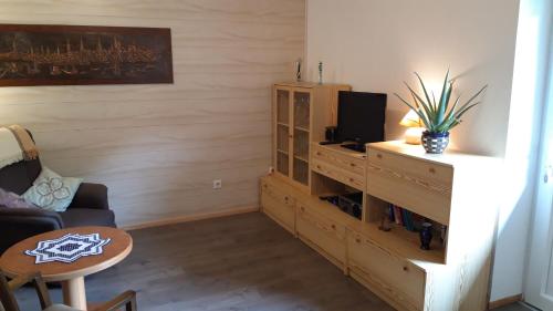 a living room with a tv and a wooden cabinet at Gasthaus Zehrermühle in Schönberg