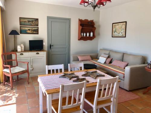 sala de estar con mesa y sofá en Les Aurochs en Grimaud