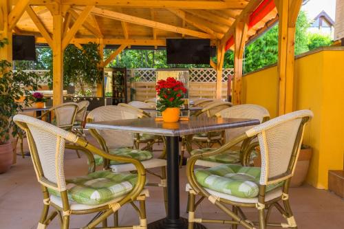 a table and chairs with flowers on a patio at Hotel Mayer Alsóörs in Alsóörs