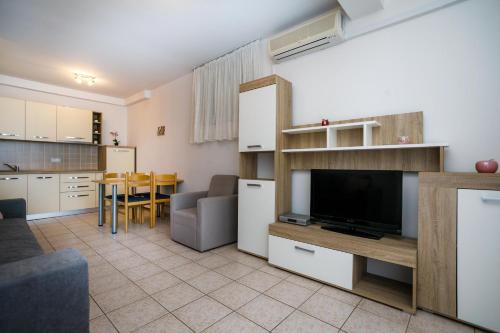 a kitchen and a living room with a tv and a table at Apartment Pirun in Baška