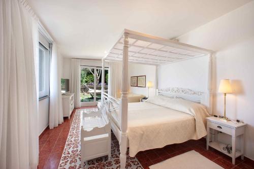 a bedroom with a canopy bed and a window at Hotel Bristol in Sorrento