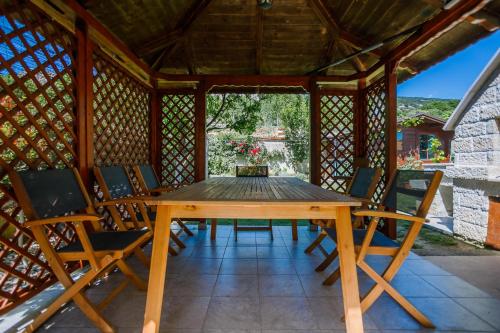 a wooden table and chairs in a gazebo at Apartment Pirun in Baška