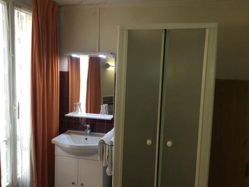 a bathroom with a sink and a mirror at A la Pinte du Nord in Paris