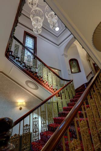 a staircase in a home with a chandelier at Trafford Hall Hotel Manchester, Trademark Collection by Wyndham in Manchester