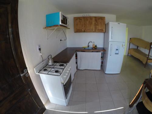 a kitchen with a stove and a white refrigerator at Alojamiento Goos in Puerto Pirámides