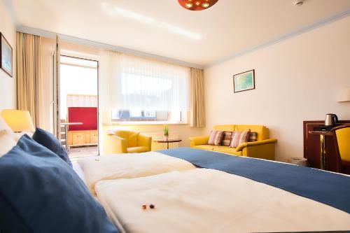 a bedroom with a bed and a living room at Hotel Meeresruh Garni in Cuxhaven