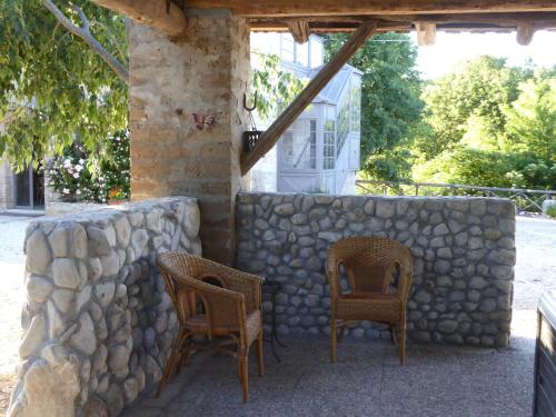 a patio with two chairs and a stone wall at Pietre di Fiume in Apice