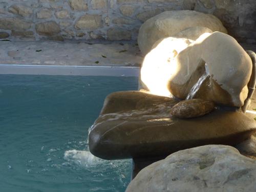 a statue of a bear sitting on a rock next to water at Pietre di Fiume in Apice