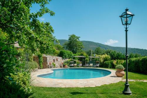 una piscina en un patio con una lámpara en Rocca Di Pierle Agriturismo di Charme, en Mercatale