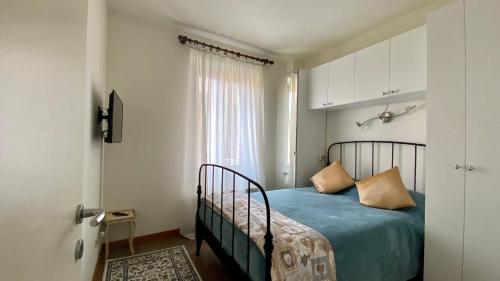 una camera da letto con un letto con lenzuola blu e una finestra di Casa Anna a Lovere