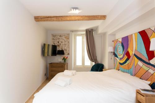 a bedroom with a white bed with a colorful headboard at MAISON PICASSO - Jacuzzi, vue, terrasse for 6 in Antibes