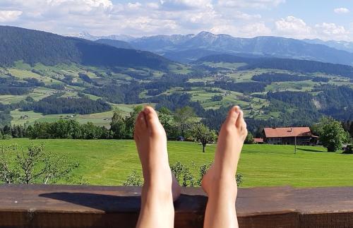 a person with their feet up on a ledge overlooking a valley at Haus Adlerhorst in Sulzberg