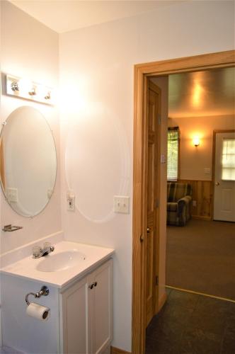 a bathroom with a sink and a mirror on the wall at Baileys Sunset Cottages in Baileys Harbor