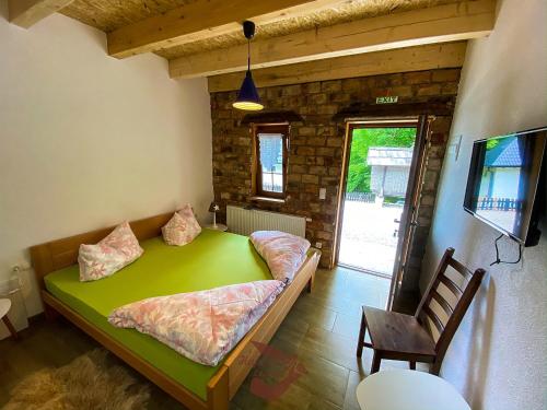 ein Schlafzimmer mit einem grünen Bett in einem Zimmer in der Unterkunft Holiday park Hajducka cesma in Dubovsko