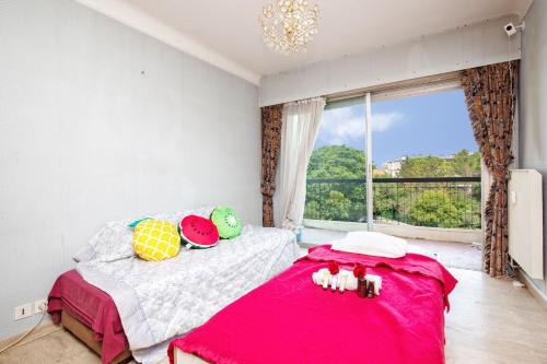 - une chambre avec un lit doté d'une couverture rose et d'une fenêtre dans l'établissement BEST Choice Dispo Cannes Centre 2 terrasses 2 chbres 6P Parking Privé, à Cannes