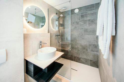 a bathroom with a sink and a shower at Amsterdam Beach Hotel in Zandvoort