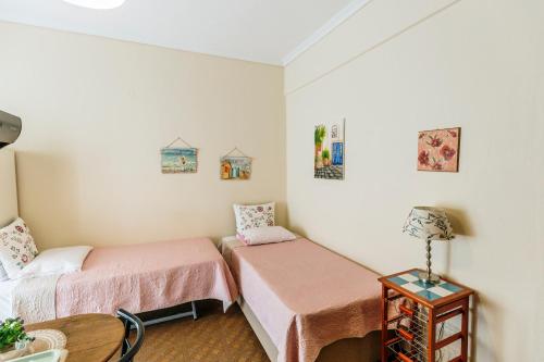 two beds in a small room with a table at Mary's Studio Kavala in Kavala