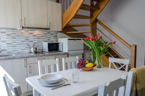 una cocina con una mesa con un tazón de flores. en Domki Betina, en Jastrzębia Góra