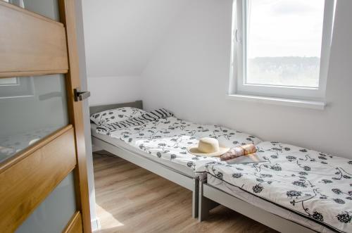Una habitación con dos camas con un sombrero encima. en Domki Betina, en Jastrzębia Góra