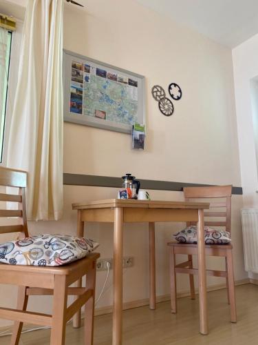 a desk with two chairs and a table and two clocks at Hotel-Pension Mandy - Adults Only in Senftenberg