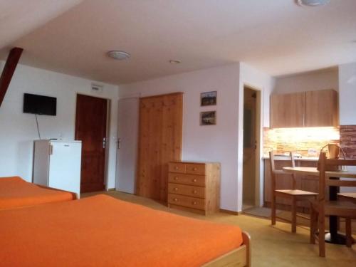 a room with two beds and a kitchen with a table at Pod Smrcinou in Nová Pec