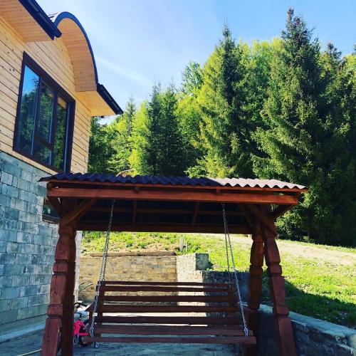 a wooden swing in front of a house at RIVIERA in Lekechi