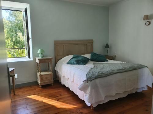 a bedroom with a bed and a window at Domaine De Marlas - Gîte de Charme in Rieucros