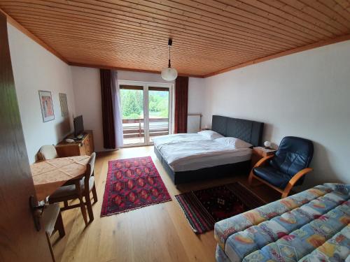 1 dormitorio con cama, sofá y mesa en Appartements Amrusch, en Sankt Jakob im Rosental