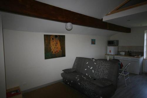 a living room with a black couch and a kitchen at La Fount del Fer in Camarade