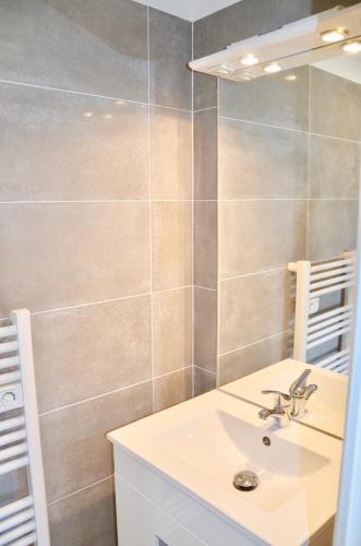 a bathroom with a sink and a mirror at La Petite Maison appartement 1 in Avoine