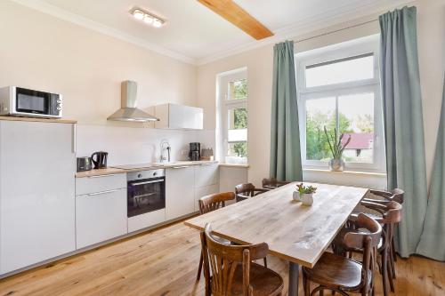 a kitchen with a table and chairs in a room at Ferienwohnung an der Brunnenaue in Stralsund
