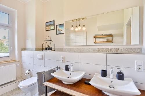 a bathroom with two sinks and a toilet at Ferienwohnung an der Brunnenaue in Stralsund