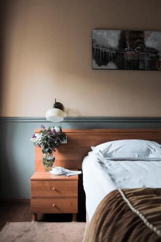 a bedroom with a bed and a table with a vase of flowers at Frapolli Hotel on Deribasivska street in Odesa