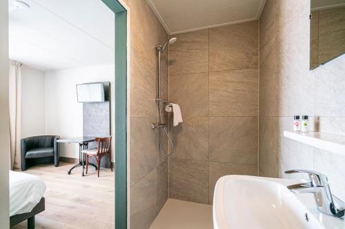 a bathroom with a shower and a sink at Hotel & Eetk'fee de VLiK in Ospel