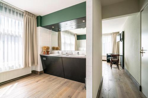 a bathroom with a sink and a mirror at Hotel & Eetk'fee de VLiK in Ospel