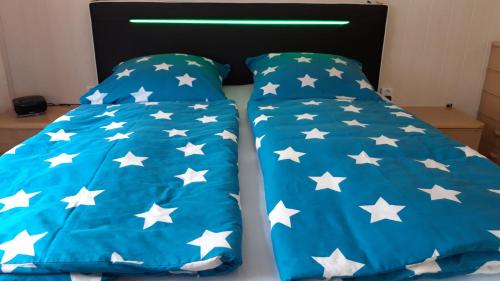 a bed with blue comforter with white stars at Gasthaus Zehrermühle in Schönberg