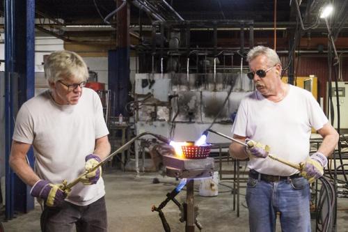 two men are working in a factory with a stick at Ängbacka in Rejmyre