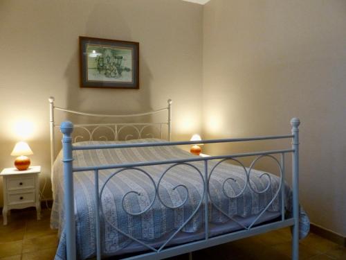 Un dormitorio con una cama de metal con una foto en la pared en Les volets verts, en Lamothe-Montravel