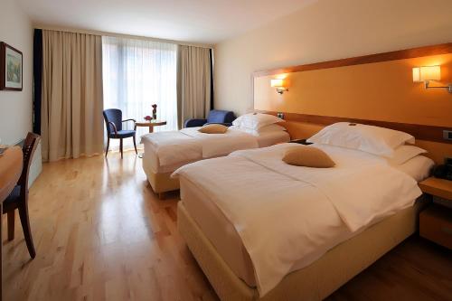 a hotel room with two beds and a table at Hotel Lovec in Bled